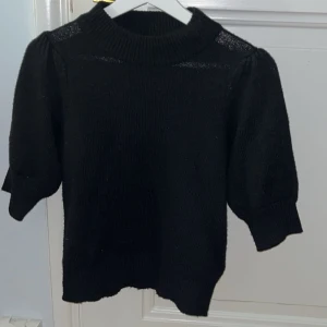 Stickad t-shirt med puffärmar - Säljer min fina stickade t-shirt som tyvärr aldrig kommer till användning, den är alltså helt i nyskick. Säljer för 150 kr