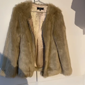 Pälsjacka - Beige pälsjacka som inte kommit till användning. fuskpäls storlek 38