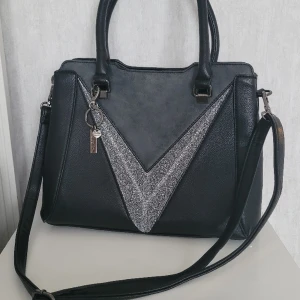 Axelväska från Dudlin - En trendig väska för alla tillfällen. Aldrig använd. L 30cm Höjd 25cm bredd 15 cm. Rymlig. Har många innerfack för ordning på dina saker.