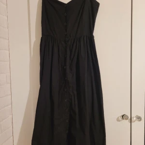 Svart klänning med knappar, strl 38 - Svart klänning med knappar som går hela vägen från topp till tå, fläckfri och i storlek 38