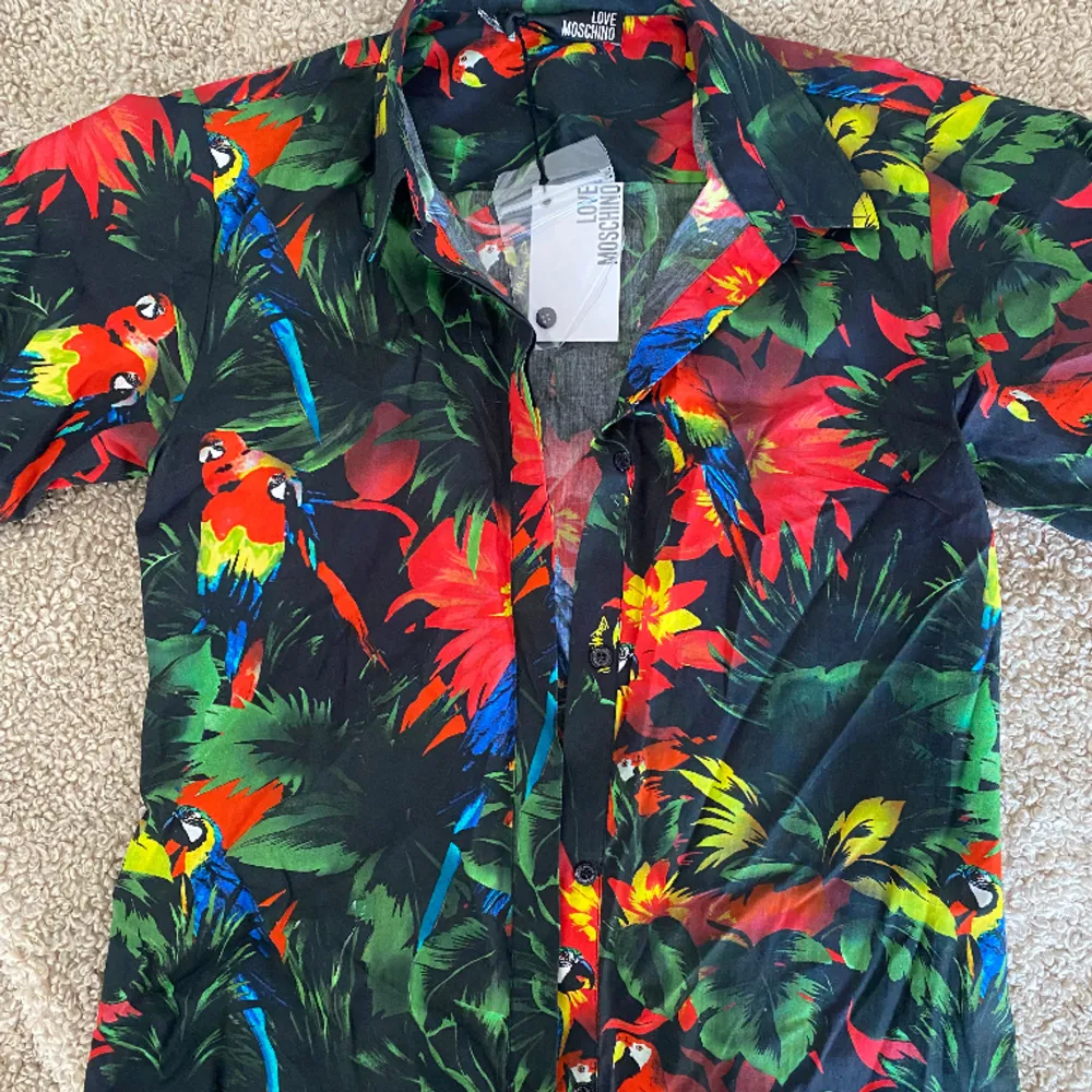 Säljer denna superfina skjorta från Moschino helt oanvänd pga för liten. Perfekt nu till sommaren.. Skjortor.