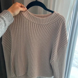 Stickad tröja - Stickad beige tröja från hm. Bra kvalitet och nopprar ej. Ganska tungt material och slutar nedanför naveln på mig. Men kommer inte till användning längre.