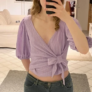 Lila omlott topp  - Topp från Monki, bara använd ett par fåtal gånger och i perfekt skick. Storlek S men borde passa M också