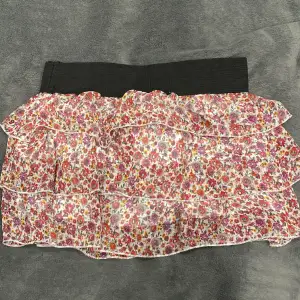 En fin kjol med volanger och blommigt mönster som är perfekt till sommaren! kort och luftig.