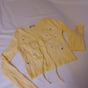 Jättesöt gul kofta med broderade blommor i nyskick i storlek s - Säljer nu denna jättefina å söta gula koftan med små broderade blommor i storlek s. Den är knappt använd så skicket är utmärkt! Köparen står för frakten och jag ansvarar ej för postens slarv. Bara att höra av er vid frågor (: