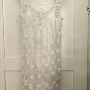 Vit klänning med blommor - Min otroliga studentklänning. Älskar denna men kommer inte komma till användning igen🩷 tunt tyg men har en underklänning så är inte genomskinlig. Från indiska i storlek xs 