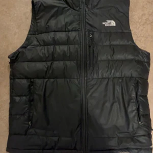 The North Face väst - Säljer den eftersom att den är för stor för mig. Storlek L. Västen har en skada som man kan se på bild 3. Org pris 1745kr.