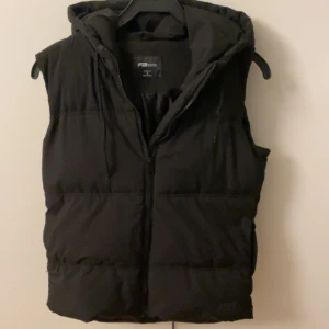 Svart väst med luva - Säljer nu en relativt tjock svart väst med luva, oklart märke men tror de heter FB sister. Jag själv har aldrig använt den men min syster har använt den ett fåtal gånger.  Allmänt fint skick.