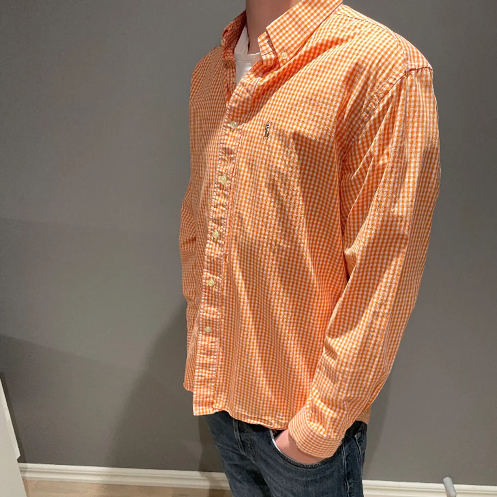 Säljer en snygg Ralph lauren skjorta i ett orange rutigt mönster. Storlek L passar M. Inga defekter på skjortan så den är i bra skick. Osäker på äkthet därav de låga priset. Han på bilden är 183cm. Nypris runt 1300, mitt pris 279. . Skjortor.