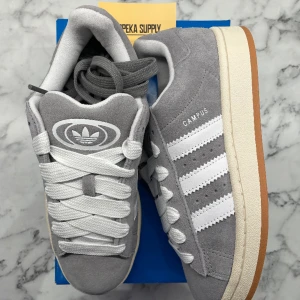 Adidas Campus 00s Grey White - Helt nya och oanvända Adidas Campus 00s Grey White i Storleken 38. Pris: 1399+frakt. Finns 1 tillgängliga i denna storlek så passa på!   Skicka ett meddelande vid intresse eller frågor. Köp gärna genom plick för bådas säkerhet😊