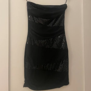 Kort glittrig axelbandslös klänning från Amisu - Jättefin kort glittrig klänning men tyvärr för liten. Använd en gång under nyårsafton. Storlek 34. I nytt skick. 