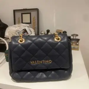 Blå Valentino axelremsväska med gulddetaljer. Jättefin. Säljes för 700 men priset kan gå ner vid snabb affär.