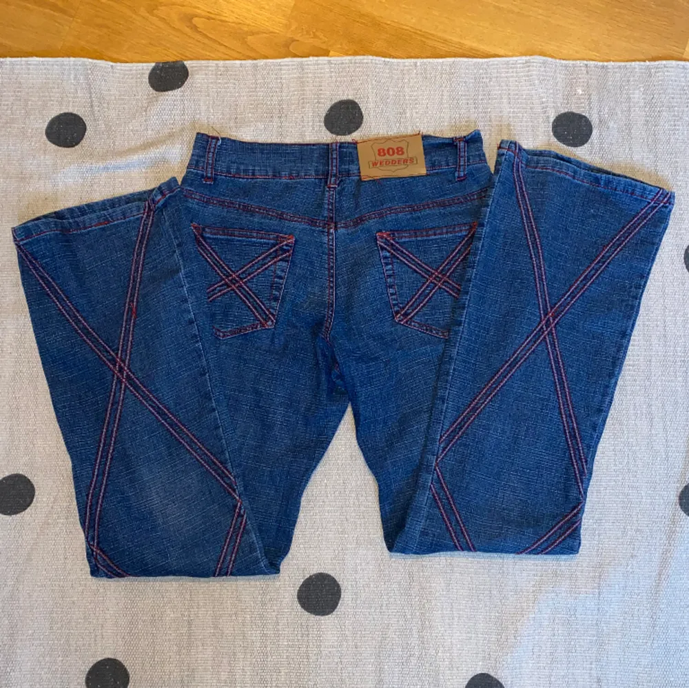 Säljer dessa jätte coola jeansen med röda detaljer! Står ingen storlek men midjemåttet är 78 cm och innerbenslängden 81 cm ungefär❤️. Jeans & Byxor.