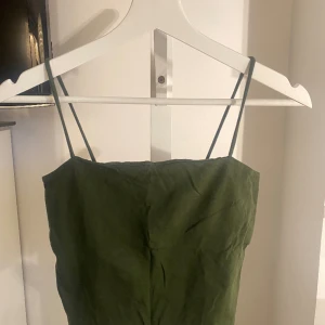 Militärgrönt linne - Croppat linne från Gina tricot, använt en gång. Finns ett extra lager med tyg vid bysten så funkar utmärkt att ha utan bh