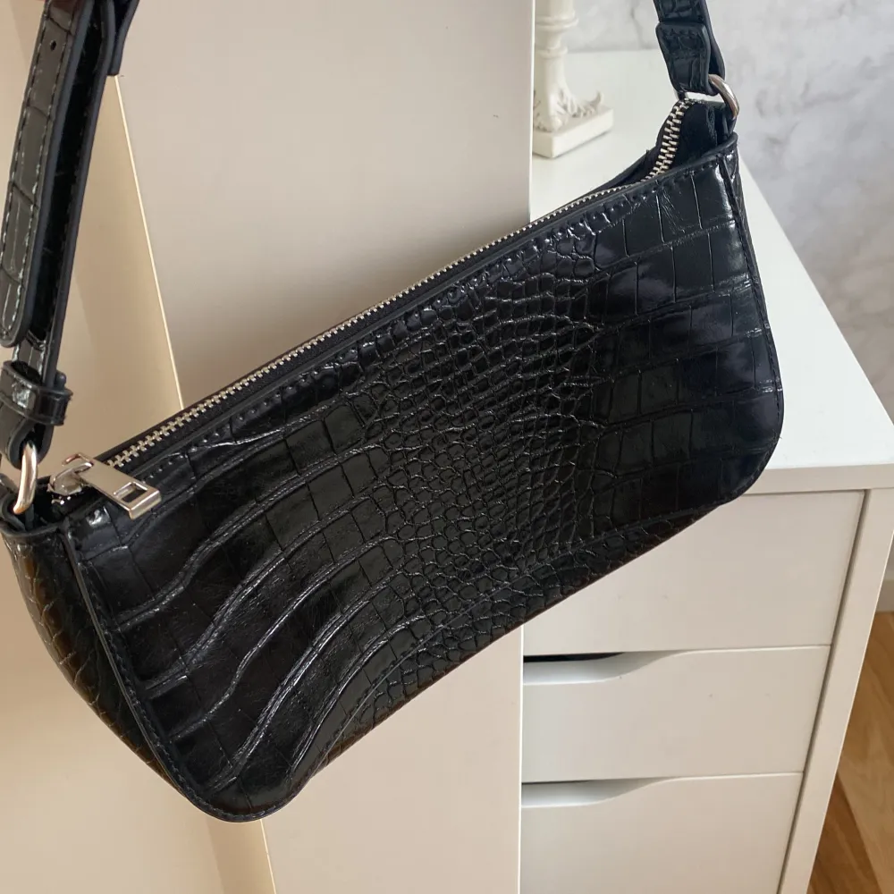 En svart handväska med silver detaljer från HM. Säljer på grund av att den inte används längre, har använts ca 5 gånger💗. Väskor.