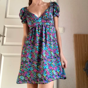 Klänning - Helt ny klänning med färgglada blommor🫶🏼 Man kan ha den vanligt vid axlarna som på första bilden eller off shoulder som på andra.  Verkligen jättefina detaljer! (puffig i ärmarna) Köpt från märket Lipsy London som inte längre säljer denna klänning🌟