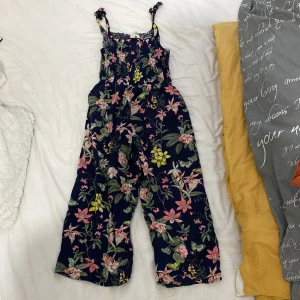 Jumpsuit från H&M - Jag vill sälja min blommiga jumpsuit från H&M den har inga skador och är i fint skick.