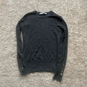 Stickad tröja med knappar  - Superskön tröja med knappar i ärmarna