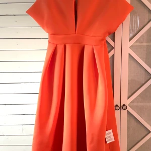 Asos klänning - Klänning från asos. Helt oanvänd, lappen sitter kvar. Nypris 800kr. Den är apelsin-orange, färgen är inte helt korrekt i det ljuset som den är tagen i!! Hör av dig om du har frågor!💗