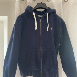 Ralph Lauren zip hoodie  - Mörkblå Ralph lauren zip tröja med gult emblem. Storlek Medium  Väl omhändertagen, kedjan fungerar precis som vanligt.  Nypris ca 1500
