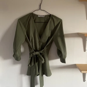 Topp från NA-KD stl 34 - En knytblus/kofta/topp från nakd i bra skick typ aldrig använd