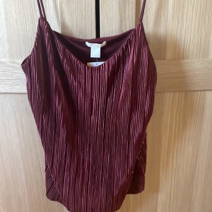 Vinröd festopp - Säljer ett Jättefin vinrött satin linne då det tyvärr är förstora för mig! Tröjan är aldrig andvänd och har lappen kvar! Den finns inte längre kvar och där av priset!