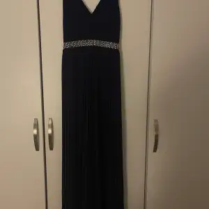 Marinblå balklänning i storlek xs/s.  Saknas väldigt få stenar.   Klänningen är använd en gång. Säljer den åt min syster och har därav ingen bild på hur den ser ut på.   Klänningen är från TFNC London.  Är cirka 150-155cm lång.  