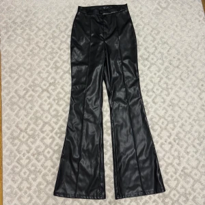 Utsvängda läder / skinnbyxor - Utsvängda läder / kostymbyxor storlek S, aldrig använda, passar även XS. Nyskick. Går att justera längden hur högt man vill de sitter 