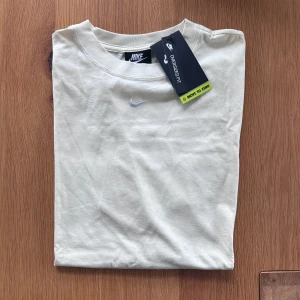 Nike T-shirt  - Helt ny och oanvänd Cremevit T-shirt från Nike.  Rensar ur min garderob från en hel del oanvända kläder🌼 Om du ser något mer i min profil som du gillar så skickar jag med det till dig också!😊 Fler kläder kommer! 