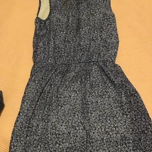 Blå blommig klänning  - En blå blommig klänning för sommaren. OBS: har en lite fläck innanför klänning 