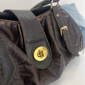 Snygg brun väska med guldiga detaljer. perfekt storlek å så snygg! 