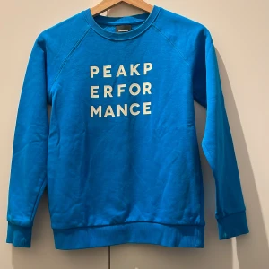 Blå peak performance tröja - Stussvidd(cm)86 Armlängd(cm)51 Skicket är nästan som ny.