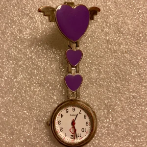 Systerur, lila 💜  - Quartz klocka, fungerande batteri. Använd ngra ggr, putsa upp lite så blir den som ny! Rostfritt stål.  Denna sjuksköterskeklocka hjälper dig hålla enkelt koll på tiden, räkna sekunder och hålla rätt på tidtagning vid omvårdnad. Nypris: 249 kr  