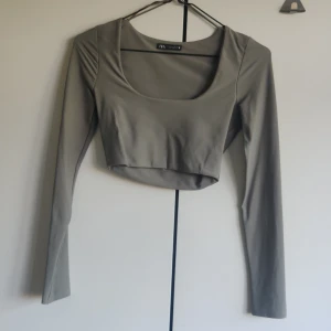 Grå croptop - Grå croptop med uringning framtill, men kan även bäras bakofram så man får lite öppen rygg. Dubbelt material. Storlek s