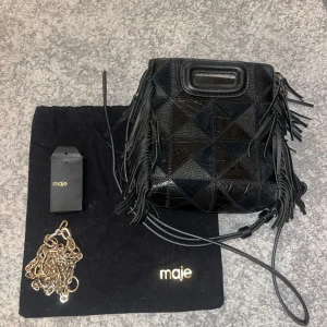 Maje väska  - INTRESSEKOLL. Kollar intresset på min super snygga maje väska. Den har två olika sidor då ena sidan har mönster och andra är hel svart. Den har inga defekter eller liknande. Bara att maje märket på väskan har suddats ut lite. 
