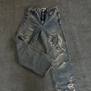 Jeans med slitningar - Ett par supersnygga jeans från Zara. De är midwaist, raka i benen med slitningar. Jeansen är i nyskick och säljs då jag inte får användning för de🤗