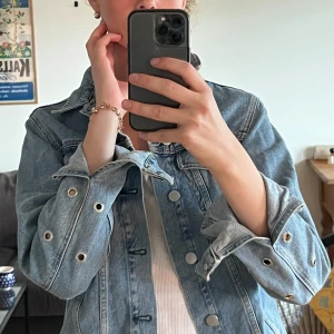 Stylad jeansjacka - Jeansjacka med öljetter bak för plats till att trä in ett fint sidenband eller vad du vill. Perfekt till sensommar festivalerna!