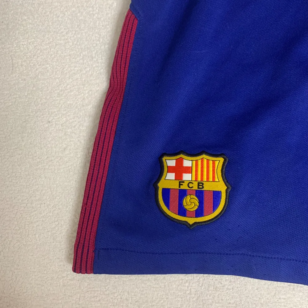 Hej, har nu ett par fina FC Barcelona shorts till salu från säsongen 2017. Den är i storlek S och köptes i FC Barcelonas fanshop i Barcelona själv! Shortsen är i bra skick men synlig använd. Ta din chans och köp snygga, äkta och billiga FCB shorts!. Shorts.