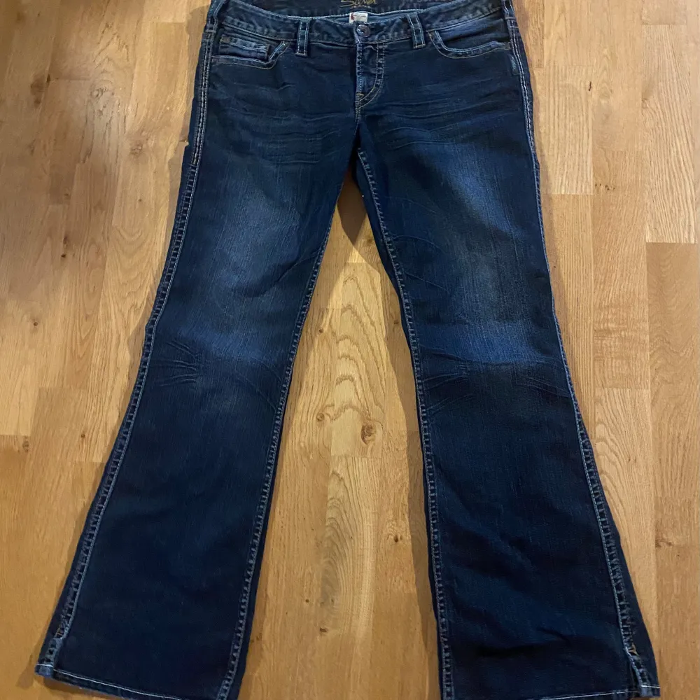 Säljer dessa jeans i bra skick i märket silver jeans eftersom de är för stora tyvärr! De har fina detaljer på fickorna och är i en mörkblå wash!! Midjemåttet från sida till sida är 43 cm och innerbenslängden är 78 cm!!. Jeans & Byxor.