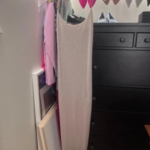 Puderrosa finklänning. Oanvänd.  - Helt ny! Storlek S. Glittrar superfint i solljus. Stretchig. 