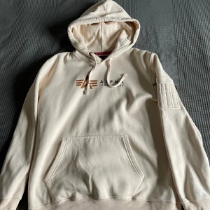 Alpha Industries luvtröja- jet stream white - Säljer nu min Alpha industries hoddie- jet stream white då jag inte använder den längre. Storlek L nypris 949kr  Inte använt den många gånger  Bra skick 