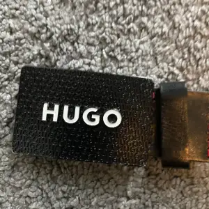 Svart Hugo Boss bälte med röda detaljer, storlek xs 