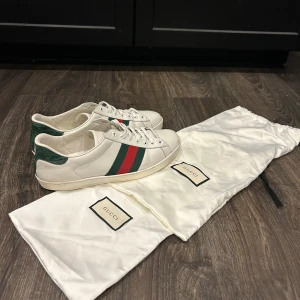 Gucci Ace skor - Säljer mina feta gucci skor i storlek 43! Skick 8,5/10. äkta, kvitto finns!! Nypris: 7400kr, mitt pris 2600kr. Dustbag och kvitto följer med! 