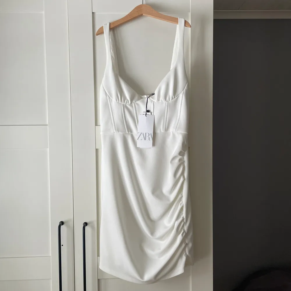 Vit kort klänning med super fin korsett. Aldrig använd (prislapp kvar), storlek S. Säljs för 150kr + frakt.. Klänningar.