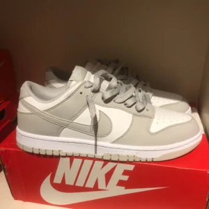 Gråa/Vita Dunks - Säljer ett par Dunks! Har använt dem litegrann men är i väldigt bra skick. 😄 Är lite för stora för mig och har legat i lådan och samlar damm! Priset kan såklart diskuteras! 