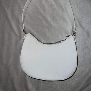En vit handväska från H&M. Använd en gång. Några ljusgråa fläckar som är ”skav” från mina andra väskor som legat emot..