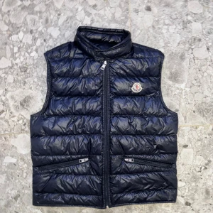Mocler Gui Väst - Mörkblå Moncler Gui väst storlek 2. Väldigt bra skick, knappt använd. Köpt på NK gbg. Dustbag finns.