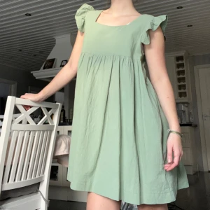 Grön klänning  - Säljer den här gröna babydoll klänningen, köpt i USA i en liten butik(nypris: ca550kr) Använd en gång som tingeling så i princip nyskick 🥰 har fickor!!