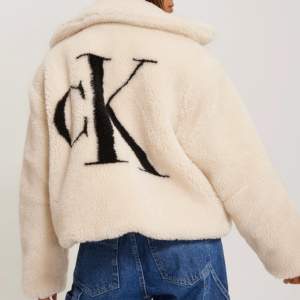 Sjukt fin jacka från Calvin Klein, jackan är i kort modell med logga på baksidan och i fint teddymaterial. Använd 1 säsong, jag har själv använt jackan när det var -10 och det var inga problem, så den är väldigt varm. 
