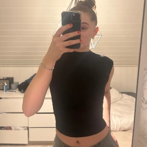 Svart topp från Gina  - Säljer denna fina topp från Gina, köpte den i somras men aldrig använt den. Tajtare i halsen och har speciella detaljer på sidan som gör att den sitter bättre. Storlek S väldigt mjukt material. 